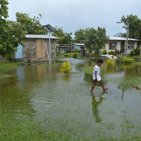 Fijian girl walks over flooded land in Fiji.
